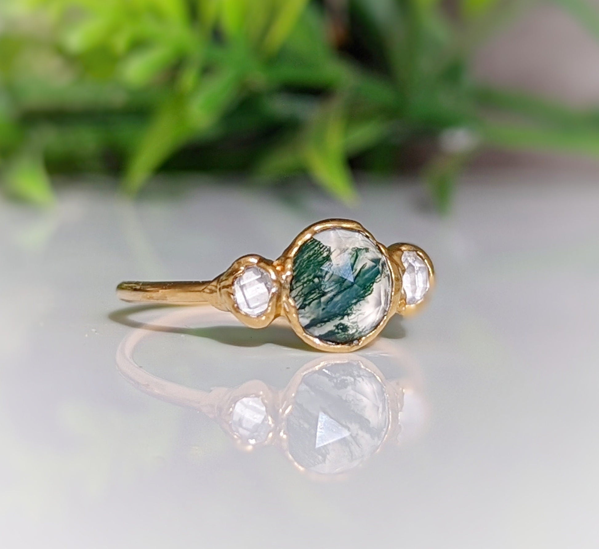 Handcrafted Moss Agate engagement ring featuring raw Herkimer diamonds set in an 18k gold band.