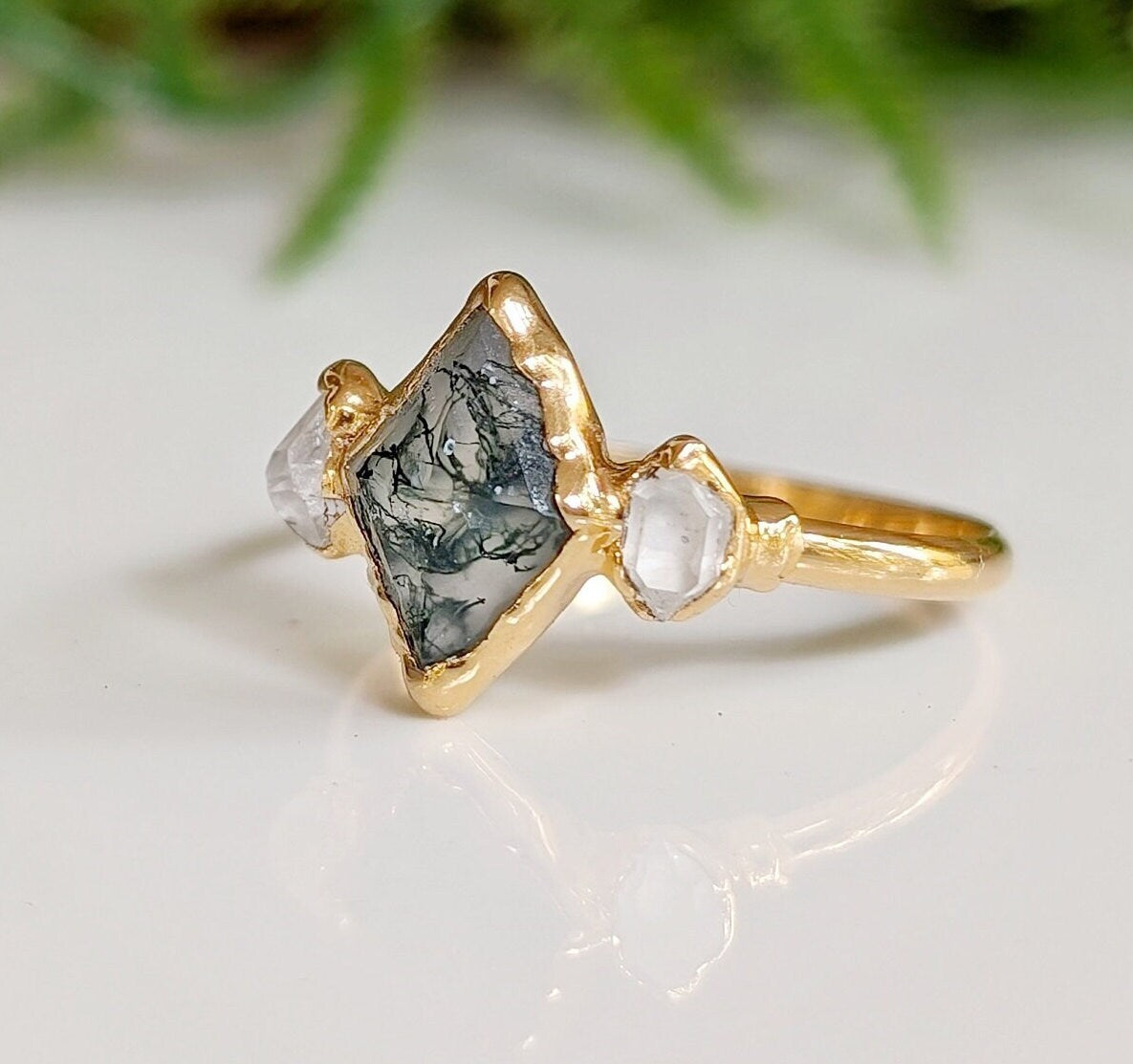 Lozenge shape Moss Agate and Herkimer diamond engagement ring on a gold band.