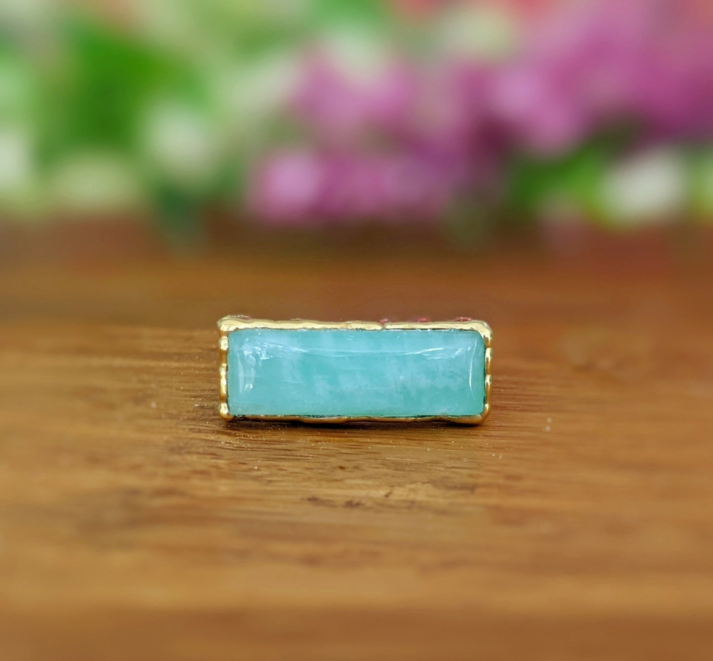 Natural Amazonite gold bar ring on wooden surface, featuring a light blue stone set in 18k gold plating.