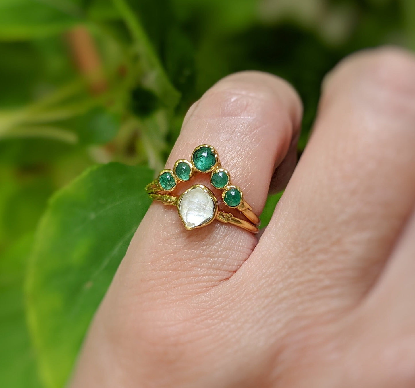 Natural Emerald Chevron wedding ring in 18k Gold worn on hand, featuring a unique design with green gemstones.