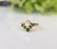 Natural emerald chevron wedding ring in 18k gold featuring a unique design with a sparkling stone and green emeralds.