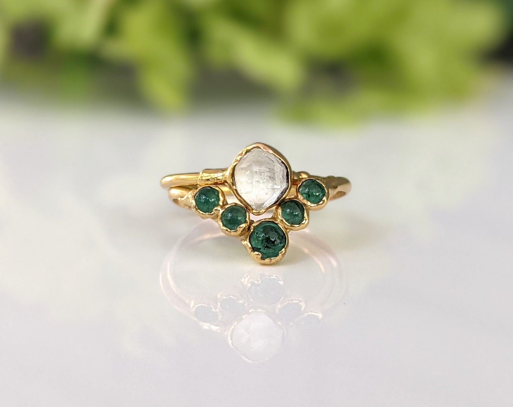 Natural emerald chevron wedding ring in 18k gold with a unique design and sparkling green gemstones.