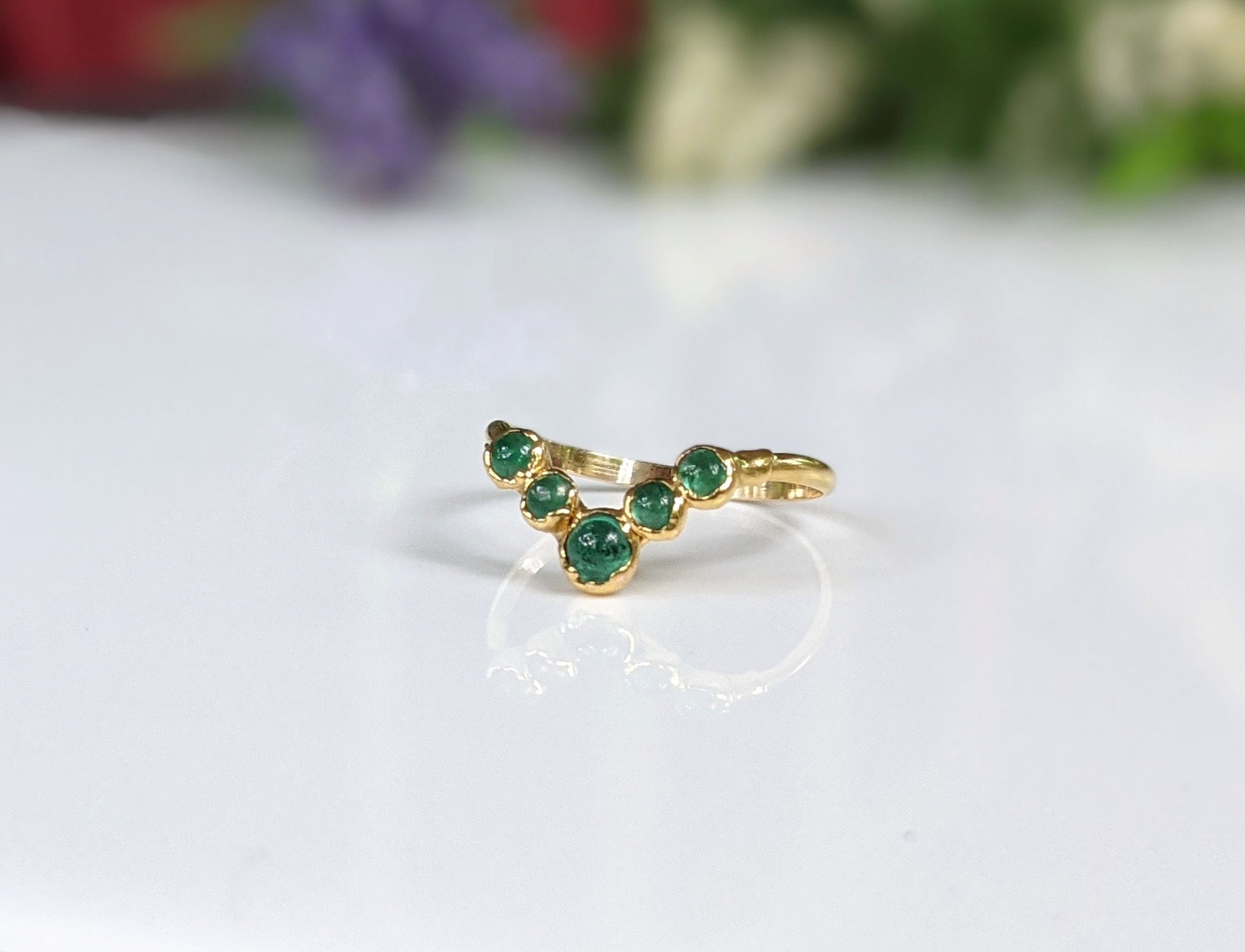 Natural Emerald Chevron wedding ring in 18k Gold showcases stunning green gemstones, ideal for love and anniversaries.