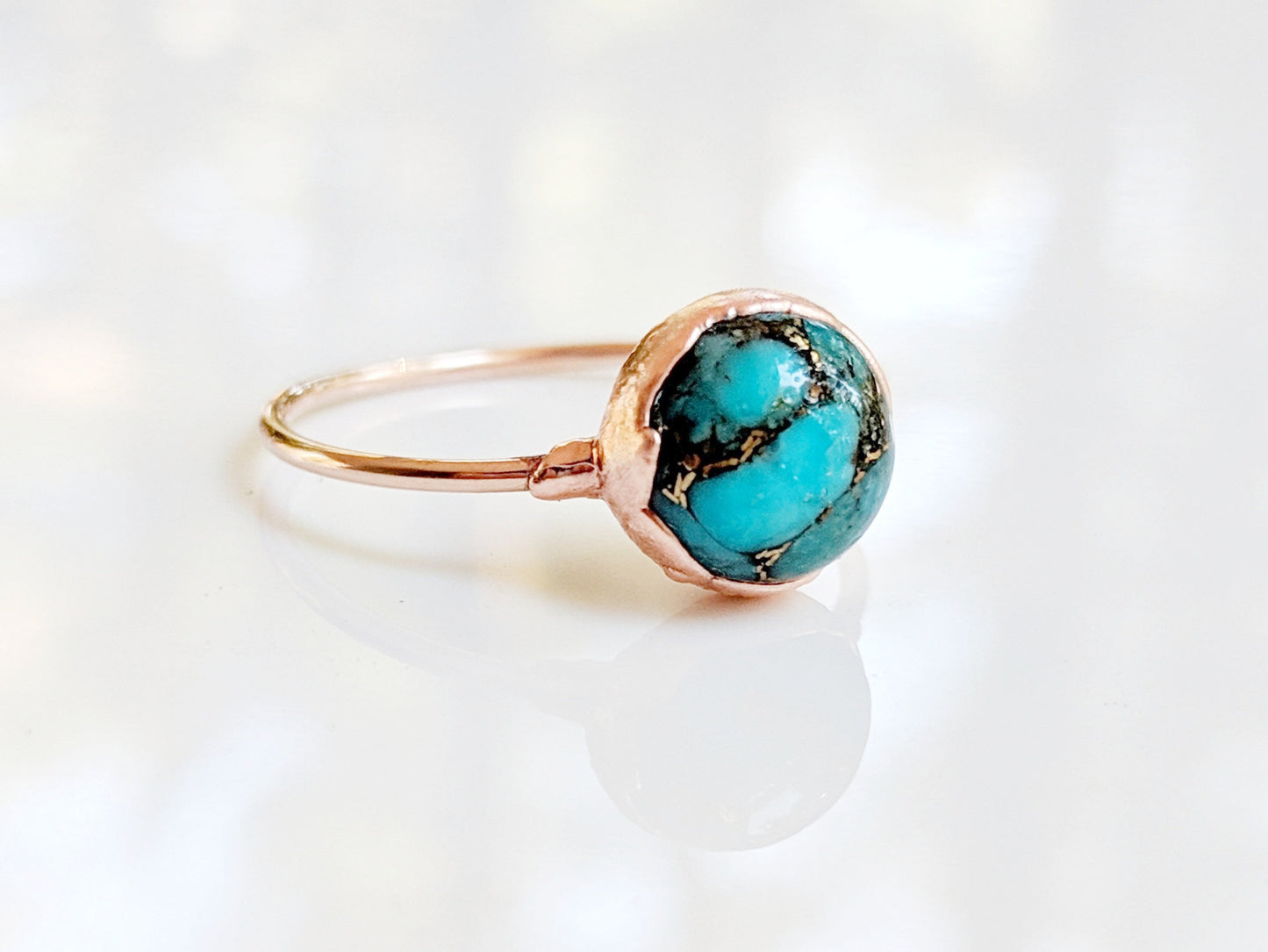 Natural turquoise ring featuring a 10mm round stone on a gold-filled band, uniquely handcrafted with vibrant colors.