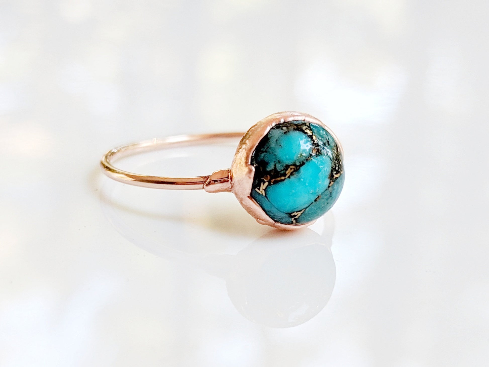 Natural turquoise ring featuring a 10mm round stone on a gold-filled band, uniquely handcrafted with vibrant colors.