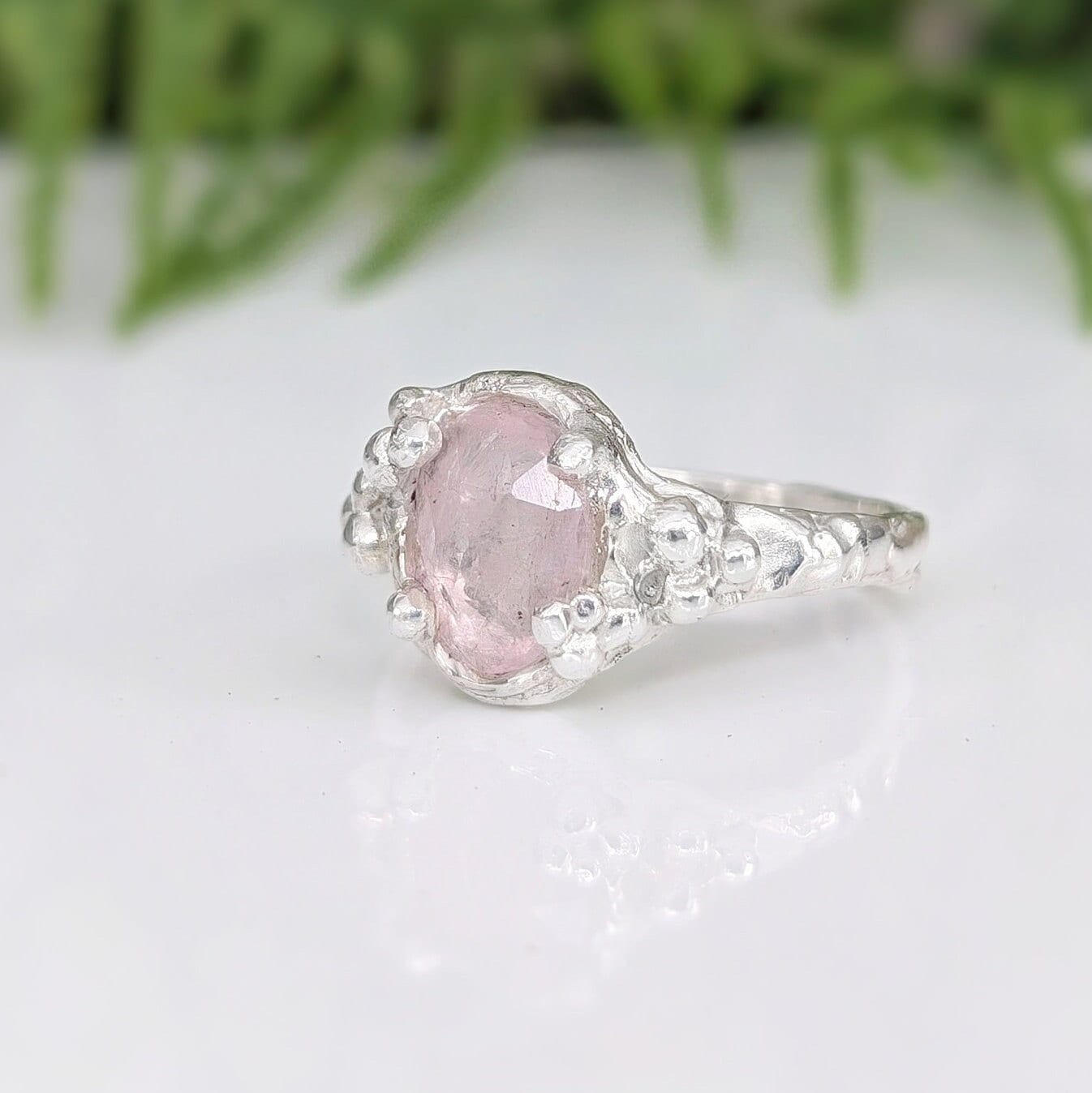 Handcrafted pink Morganite engagement ring in sterling silver with flower detail, showcasing natural elegance.