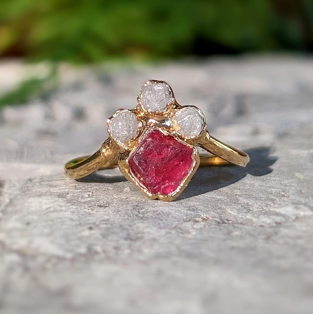 Handcrafted engagement ring featuring a raw pink spinel and diamonds in gold chevron design.