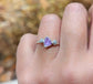 Hand wearing a raw Alexandrite and diamond silver ring, showcasing unique gemstones in natural light.