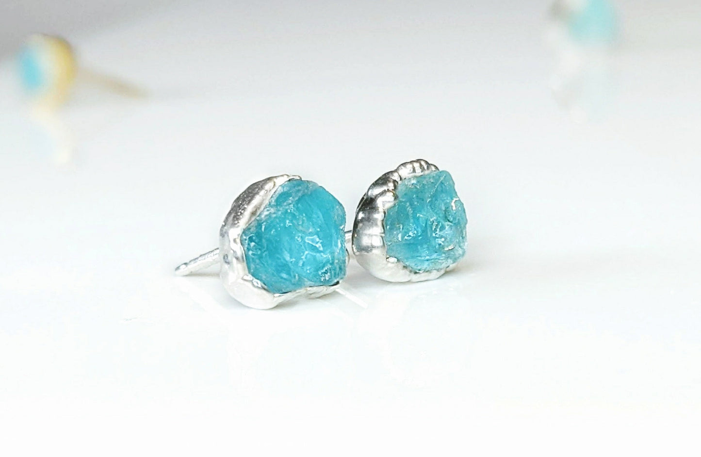 Dainty raw Aquamarine stud earrings set in silver, showcasing their rustic charm and unique textures.