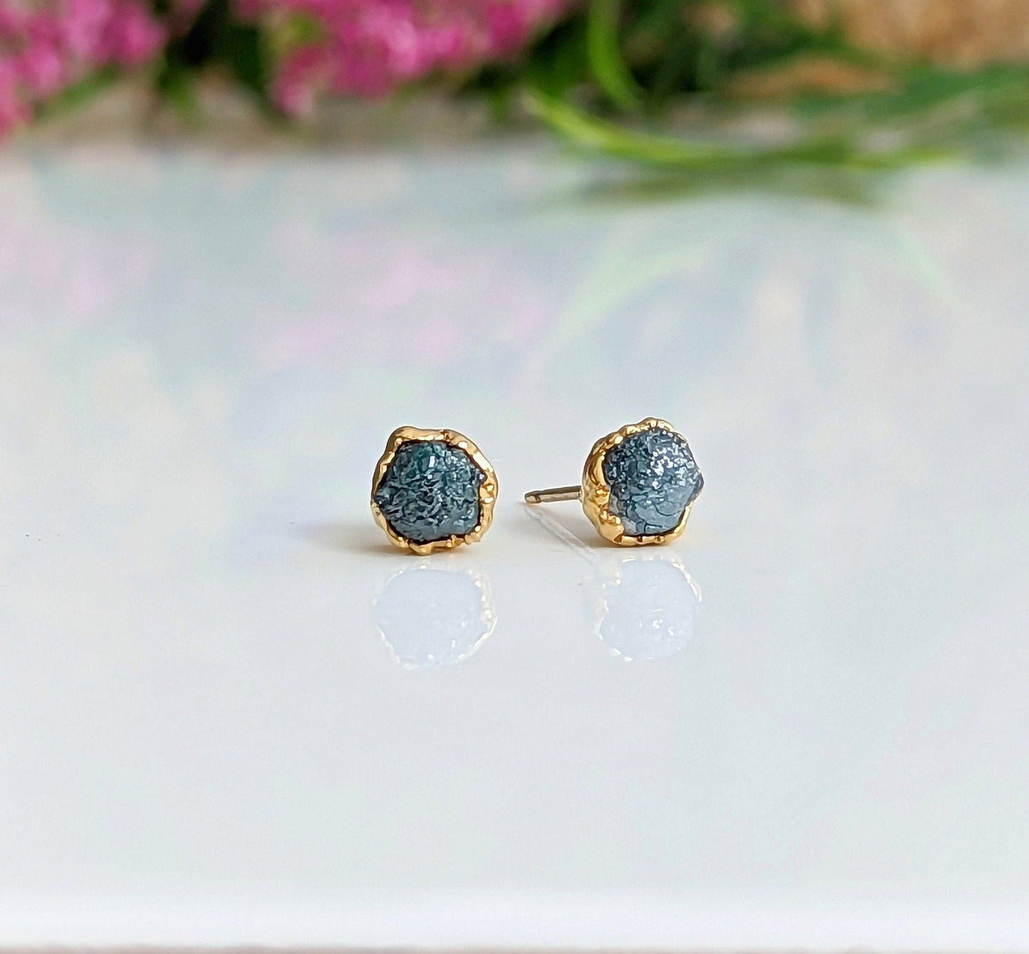 Handcrafted raw blue diamond stud earrings with gold setting, perfect for elevating any bridal or casual look.