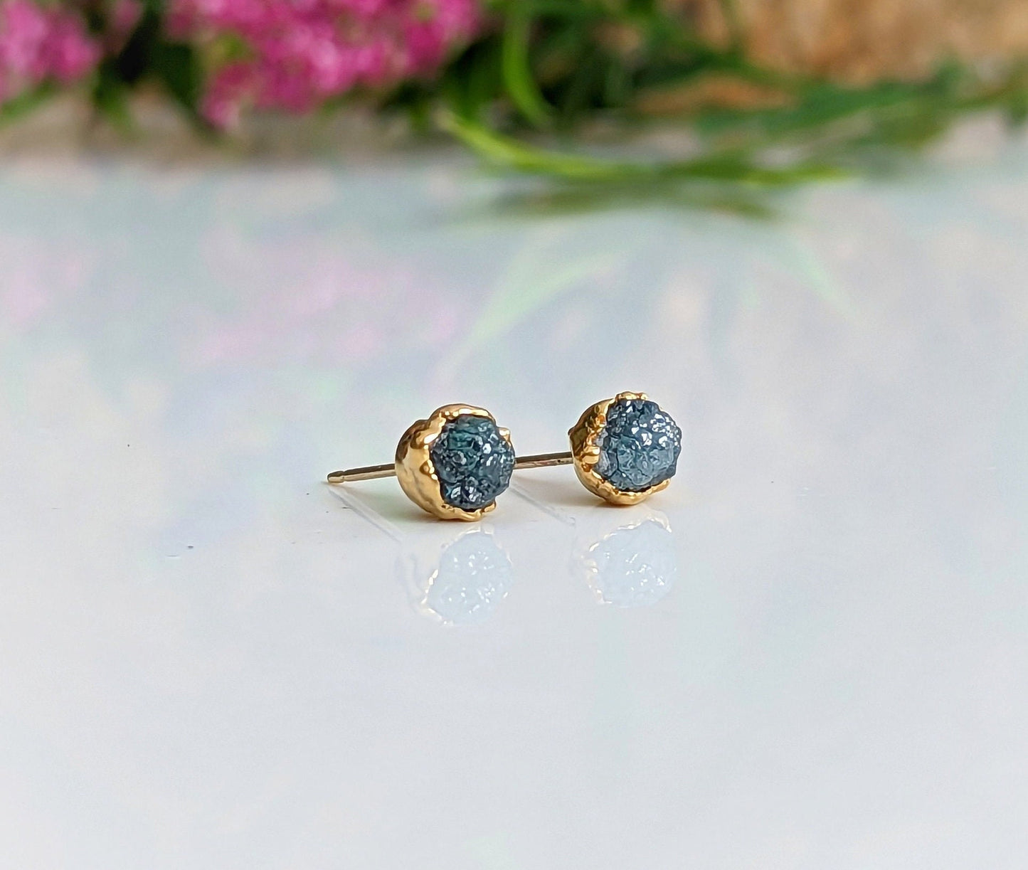 Raw blue diamond stud earrings with gold setting, perfect for bridal or casual looks.