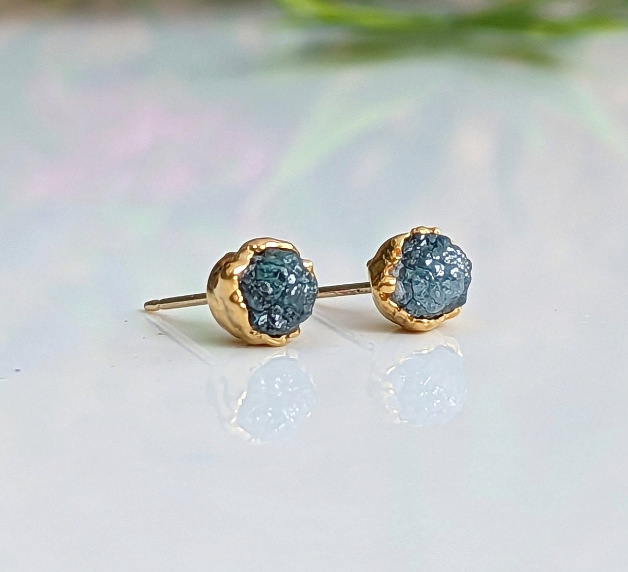 Raw blue diamond stud earrings in gold setting, perfect for bridal or casual wear, radiating timeless beauty.