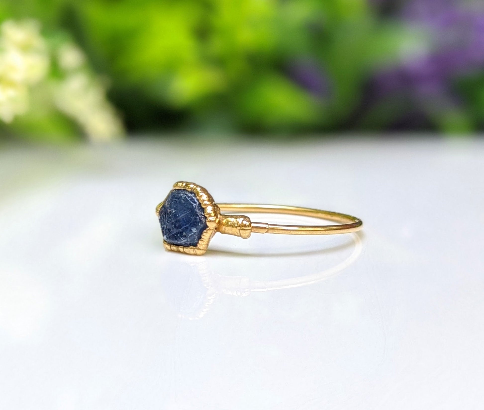 Handcrafted raw blue Sapphire ring on a 14k Gold band, highlighting the natural stone in a beautiful setting.