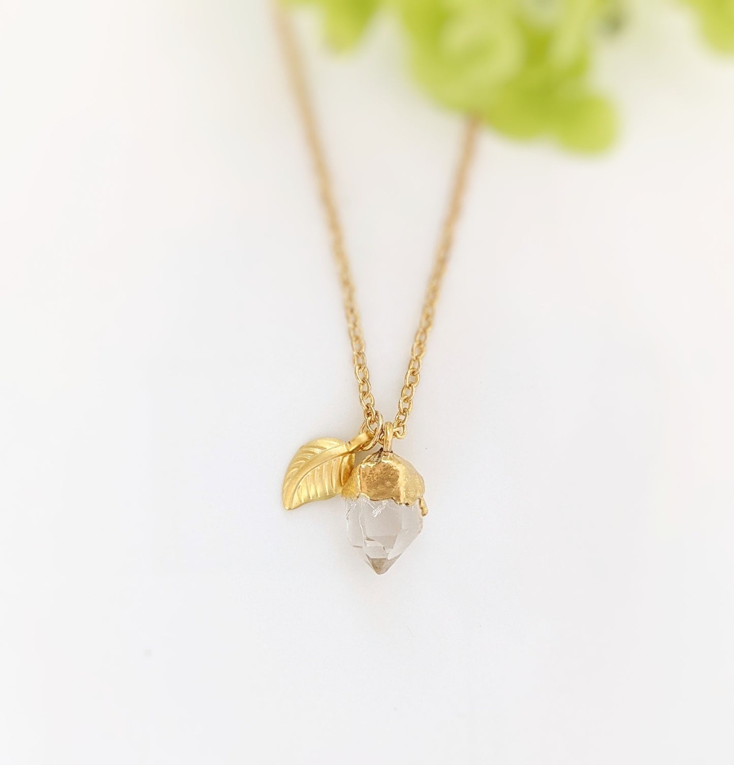 Handcrafted raw crystal necklace with gold chain and leaf charm, perfect for unique birthday gifts.