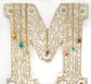 Handcrafted raw crystal and gemstone necklaces on a decorative letter M, showcasing vibrant birthstones.