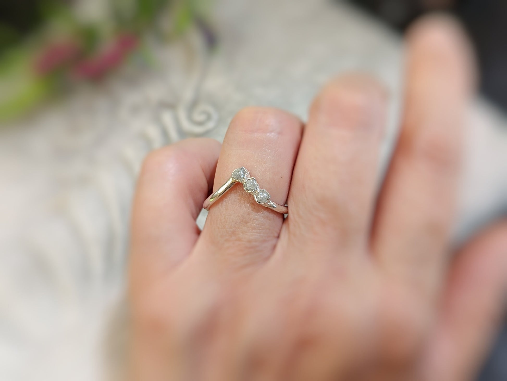 Raw diamond Chevron engagement ring on a hand, showcasing unique design and ethically sourced diamonds.