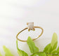Delicate raw diamond engagement ring on a gold prong band, showcasing a sparkling conflict-free diamond.