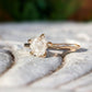 Raw diamond engagement ring in 14k gold setting showcasing uncut diamond's natural beauty.