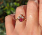 Raw diamond and pink spinel chevron engagement ring showcased on a hand, symbolizing love and elegance.