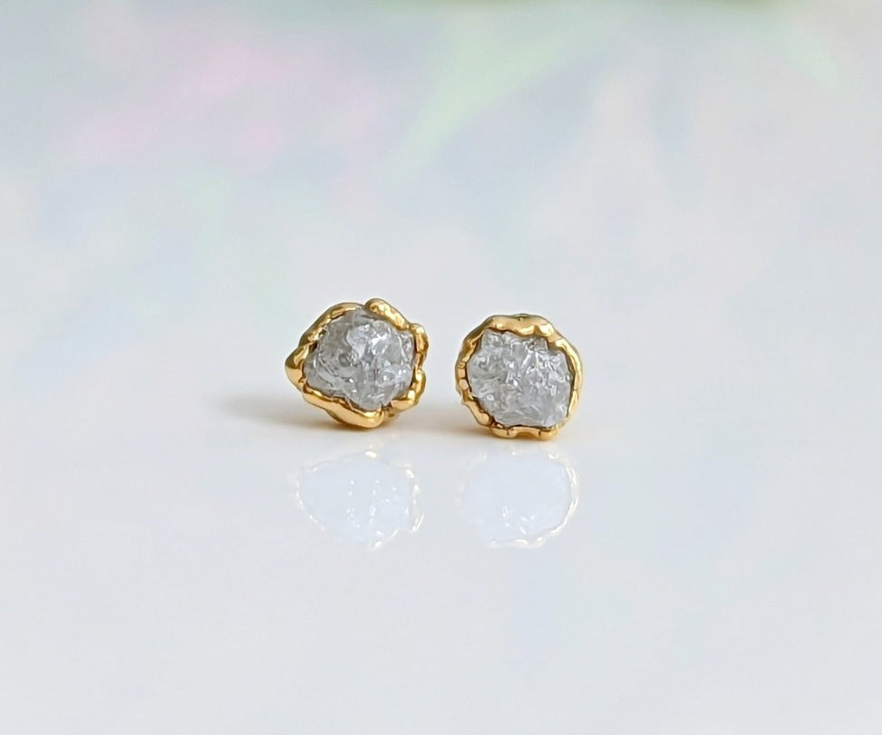 Handcrafted raw diamond stud earrings with gold setting, radiating timeless beauty and elegance.