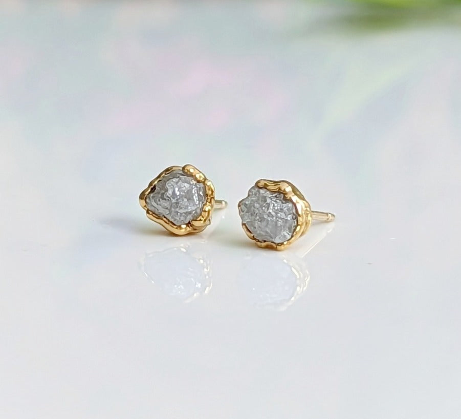 Handcrafted raw diamond stud earrings with gold edges, showcasing uncut natural beauty and timeless elegance.