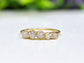 Raw diamond wedding band in gold featuring five small conflict-free diamonds on a delicate band.