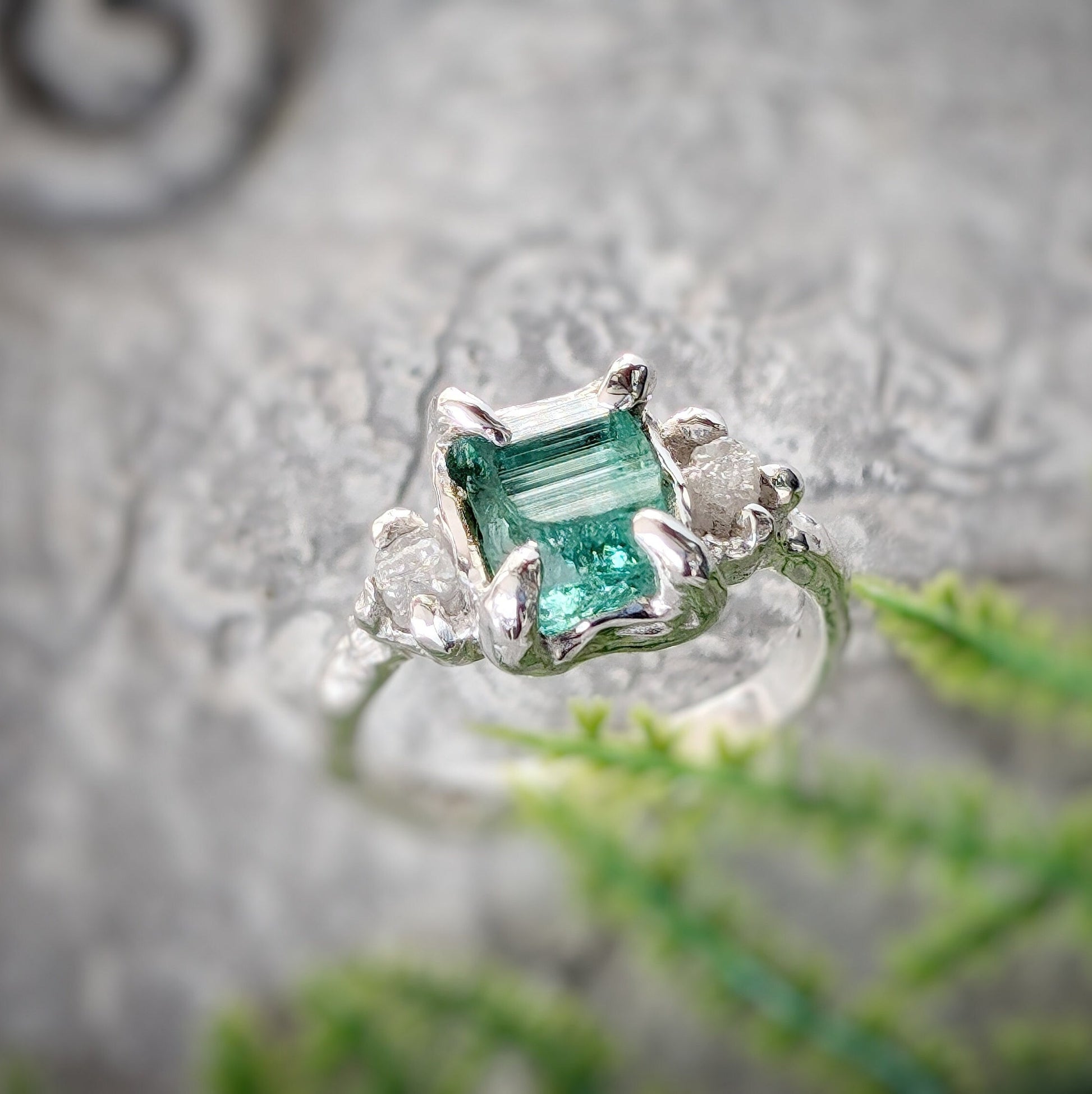 Raw emerald and diamond engagement ring in solid 14k gold, featuring a mint green emerald and conflict-free diamonds.