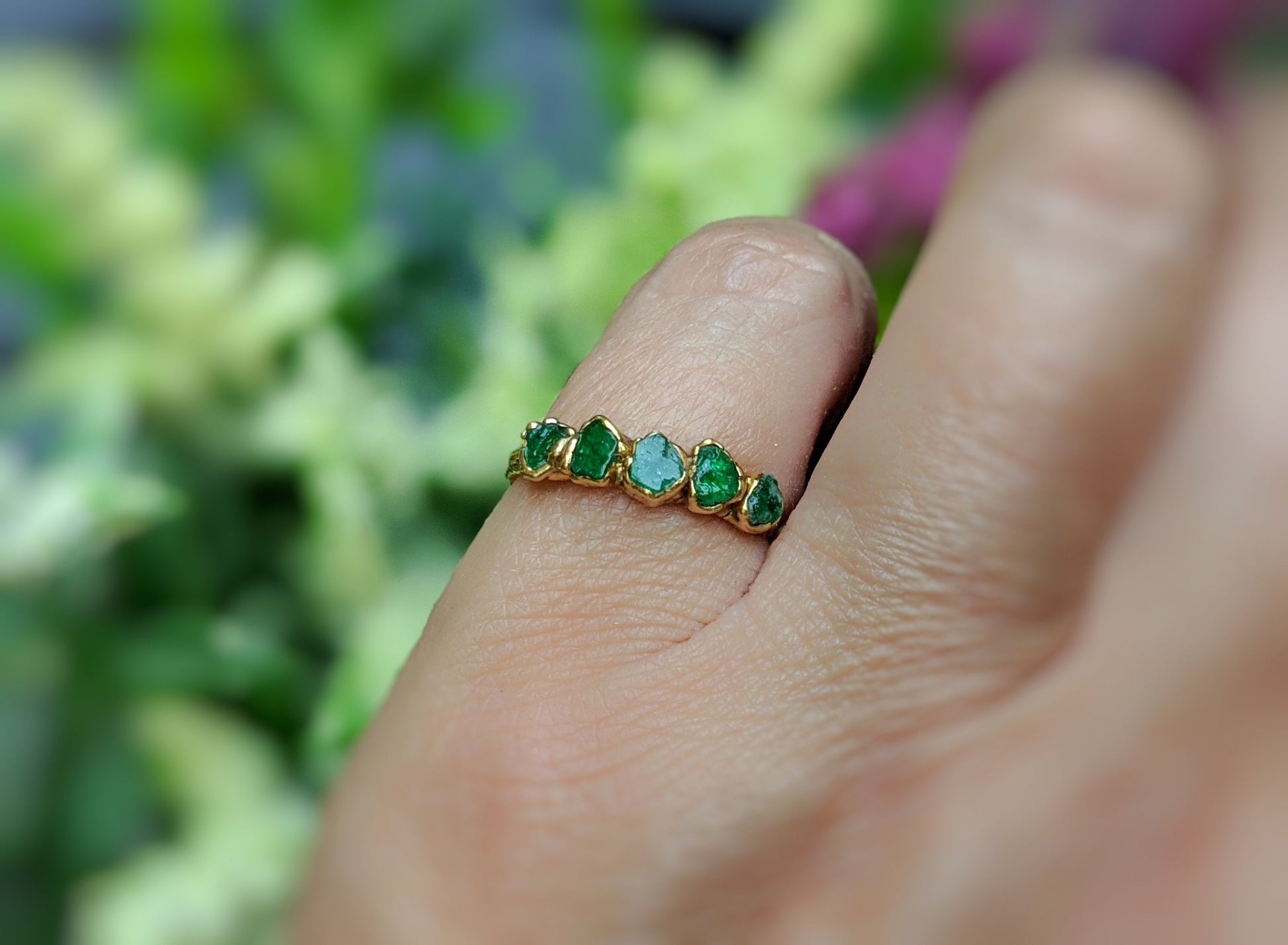 Handcrafted raw Emerald multi-stone ring on a hand, featuring a solid 14k Gold band, ideal for May birthdays.