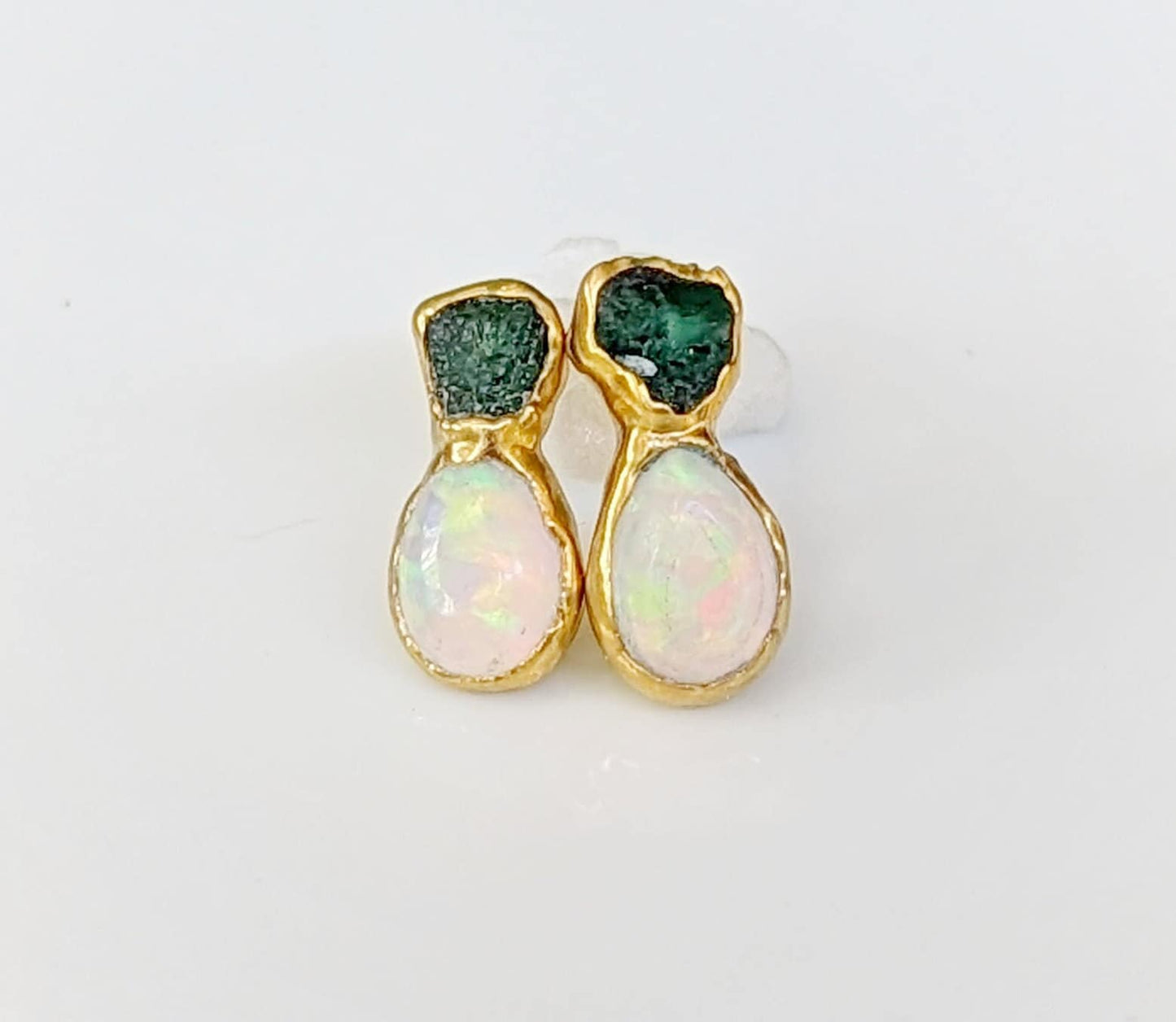 Dainty raw emerald and opal stud earrings, handcrafted in gold. Unique design for bridal or everyday wear.
