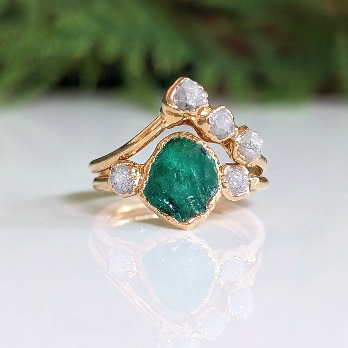 Raw emerald and diamond Chevron wedding ring set on gold band, perfect for nature lovers.