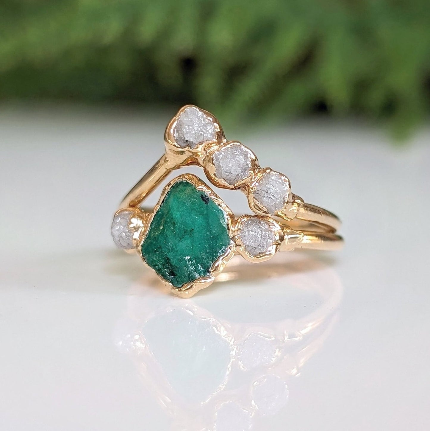 Raw emerald and diamond Chevron wedding ring set on 18k gold band, perfect for nature lovers.
