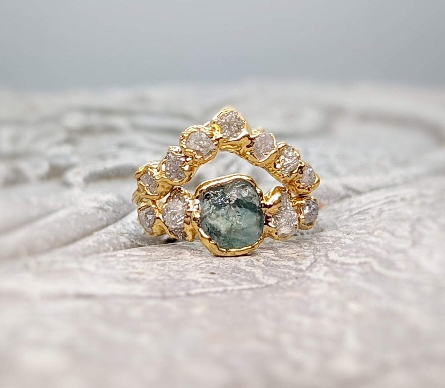 Raw Montana Sapphire and diamond bridal ring set in gold, featuring unique teal sapphire and conflict-free diamonds.