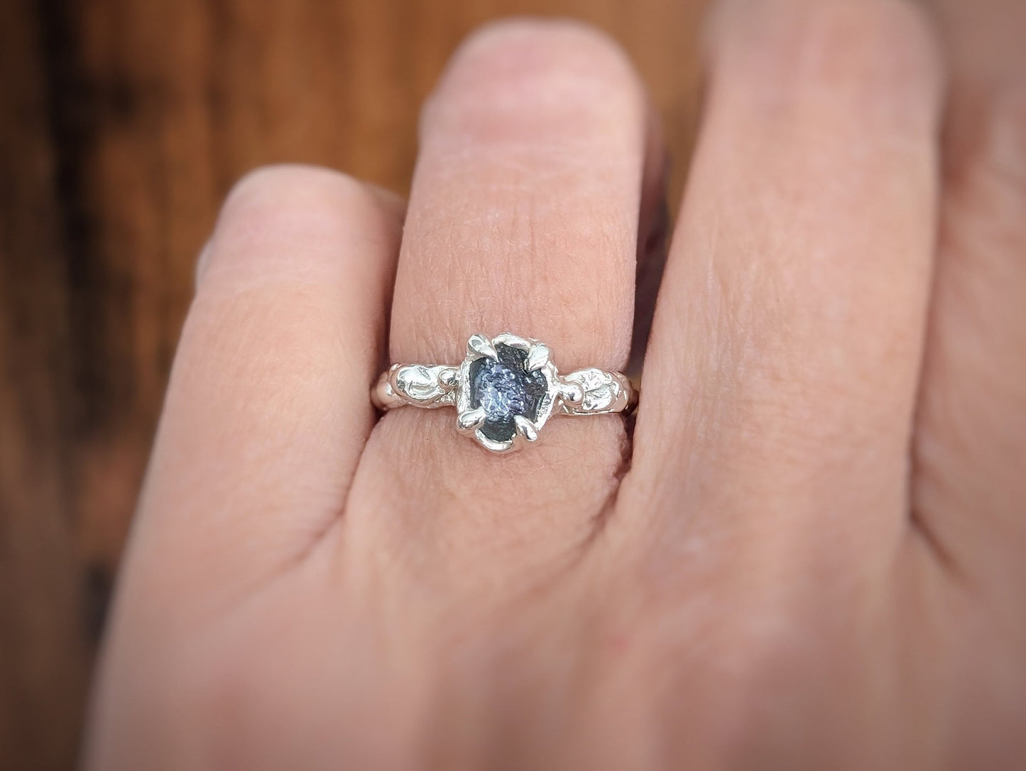 Raw Montana Sapphire engagement ring in Solid 14k Gold on a hand, showcasing its organic design and unique beauty.
