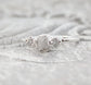Handcrafted raw diamond engagement ring with one large and two smaller raw diamonds, set in silver.