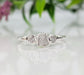 Handcrafted raw diamond engagement ring featuring a large center diamond with two smaller diamonds on a silver band.