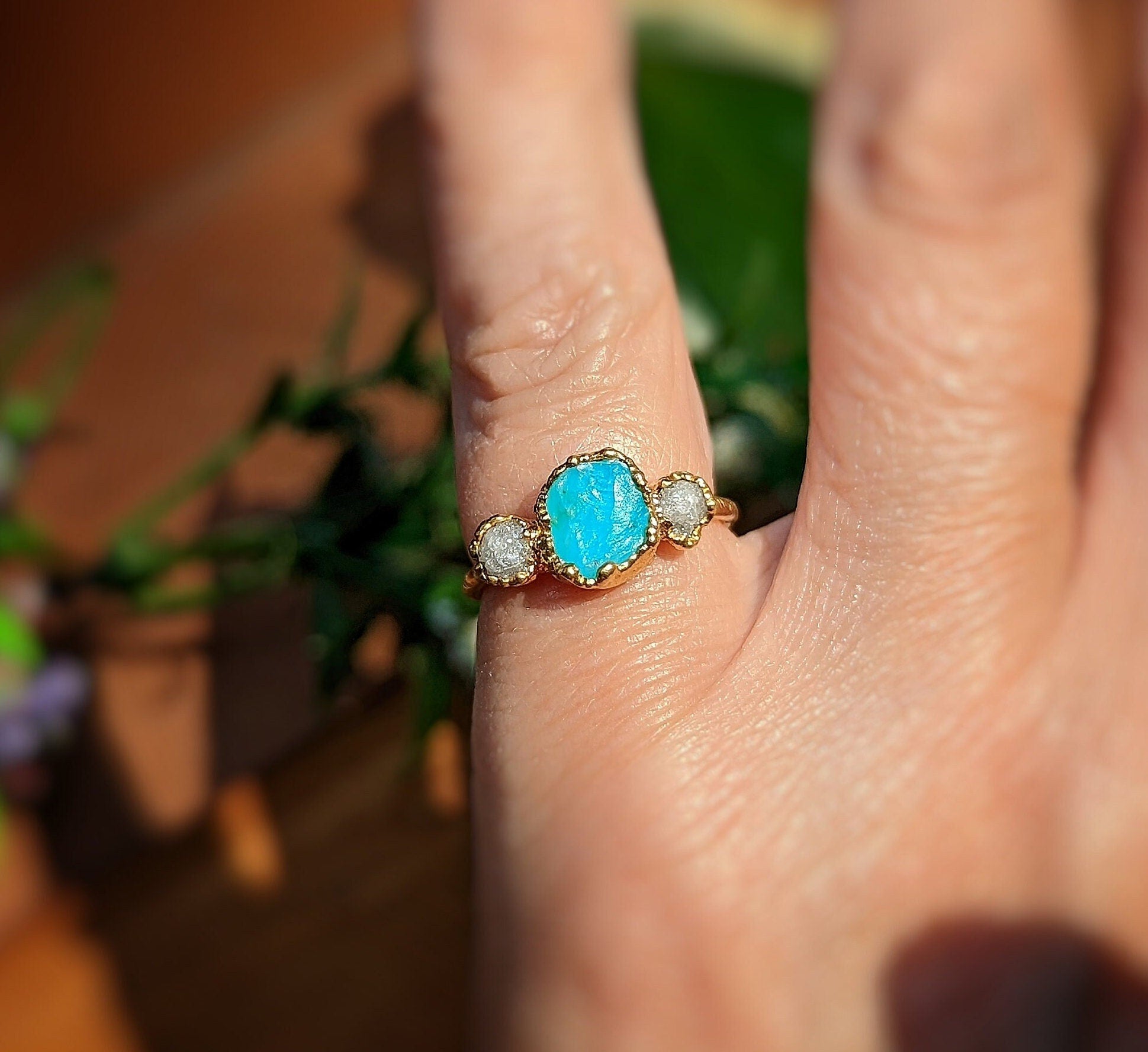 Raw Peruvian Opal and diamond ring in solid 14k gold, featured on hand with floral background.