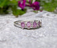 Raw pink sapphire eternity ring on a sterling silver band, perfect for gifts and special occasions.