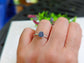 Handcrafted raw sapphire ring on a finger, featuring a unique hexagonal design on a sterling silver band.