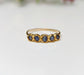 Raw sapphire multi-stone eternity ring on a solid 14k gold filled band, featuring small blue sapphires.