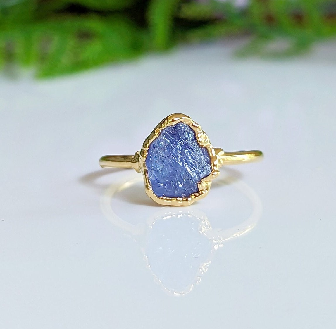 Raw Tanzanite gemstone set in a handcrafted gold ring, showcasing a unique and elegant design.