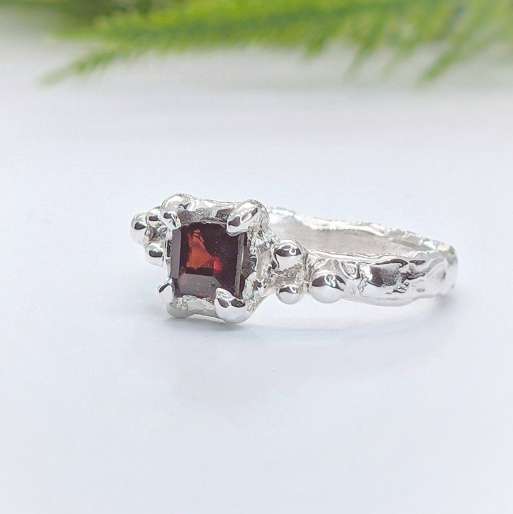 Unique Red Garnet engagement ring in solid sterling silver with an organic textured band.