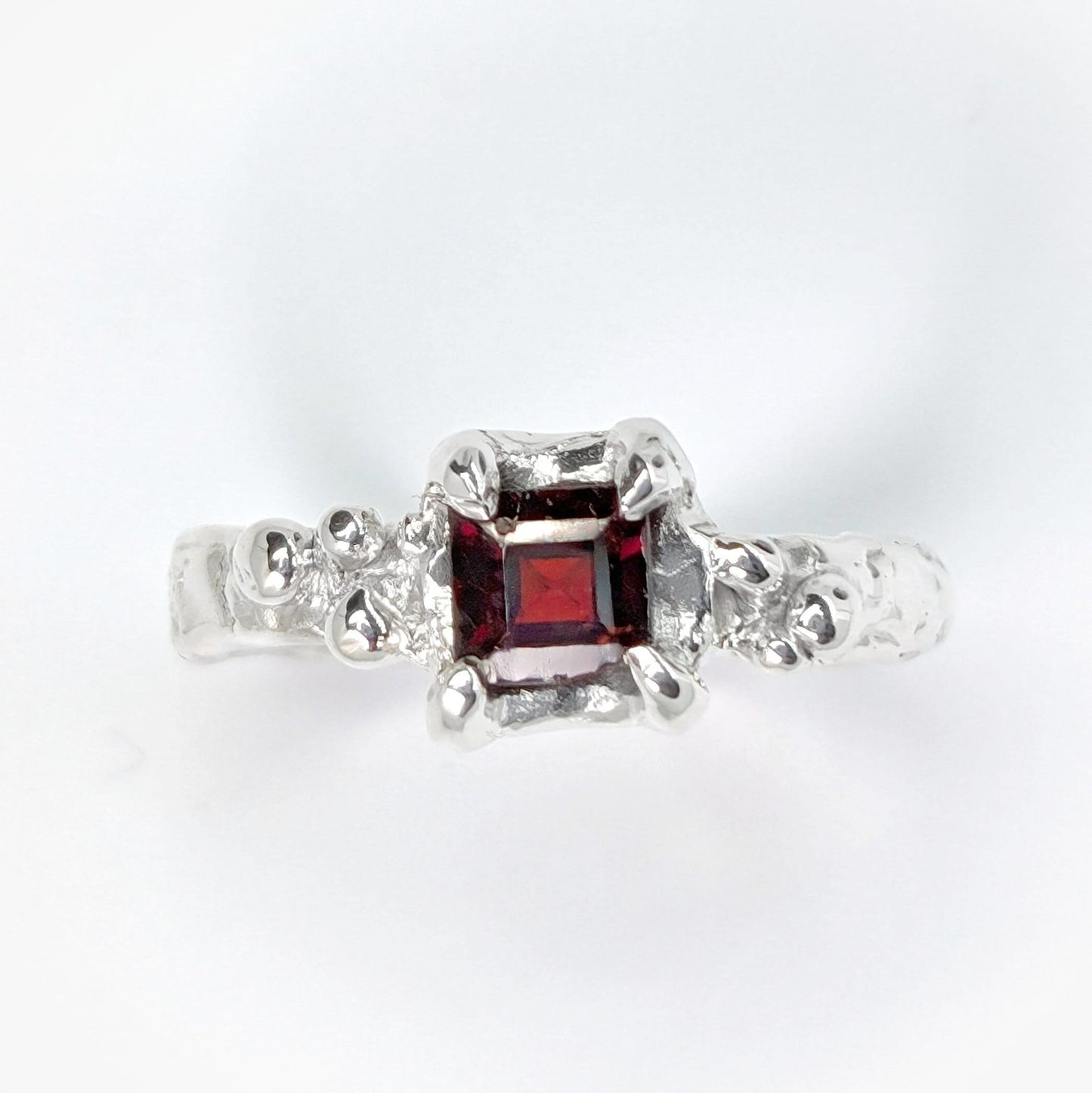 Red Garnet engagement ring in solid sterling silver with an organic textured band.