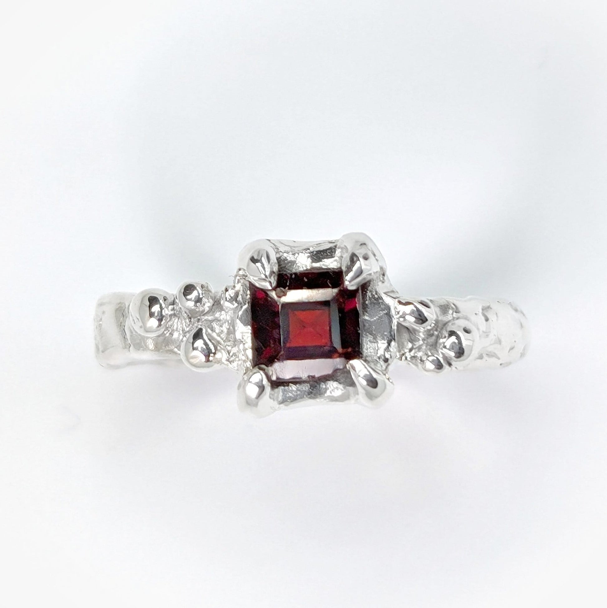 Red Garnet engagement ring in solid sterling silver with an organic textured band.