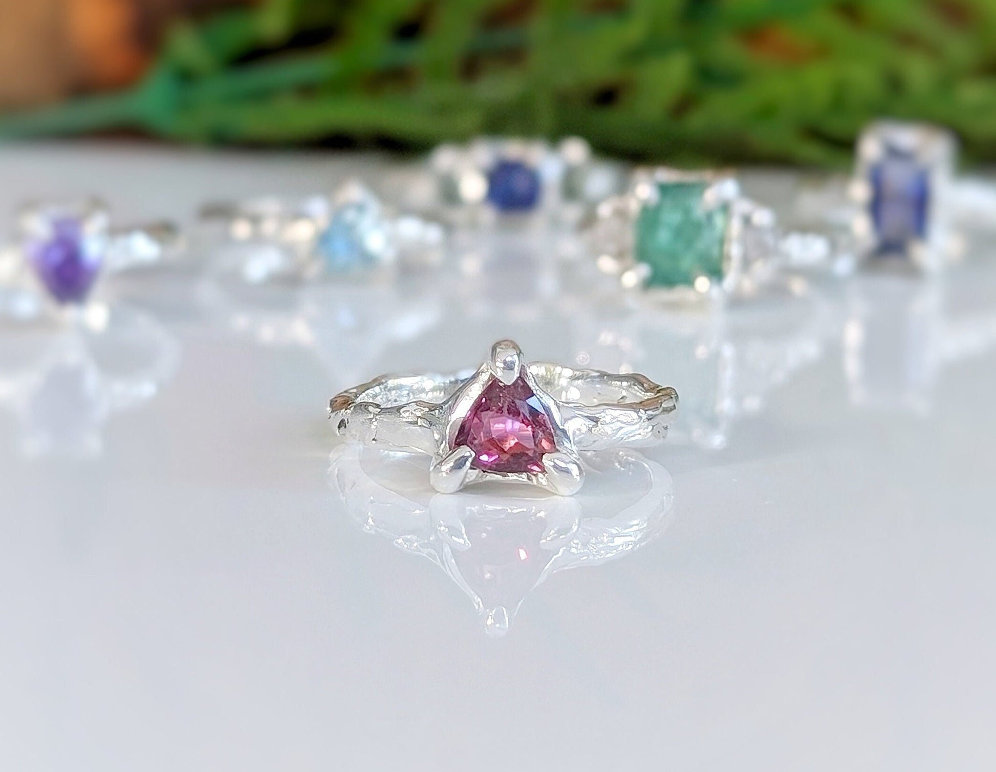 Rubellite Tourmaline engagement ring in solid 14k gold, showcasing a trilliant-cut gemstone and textured band.