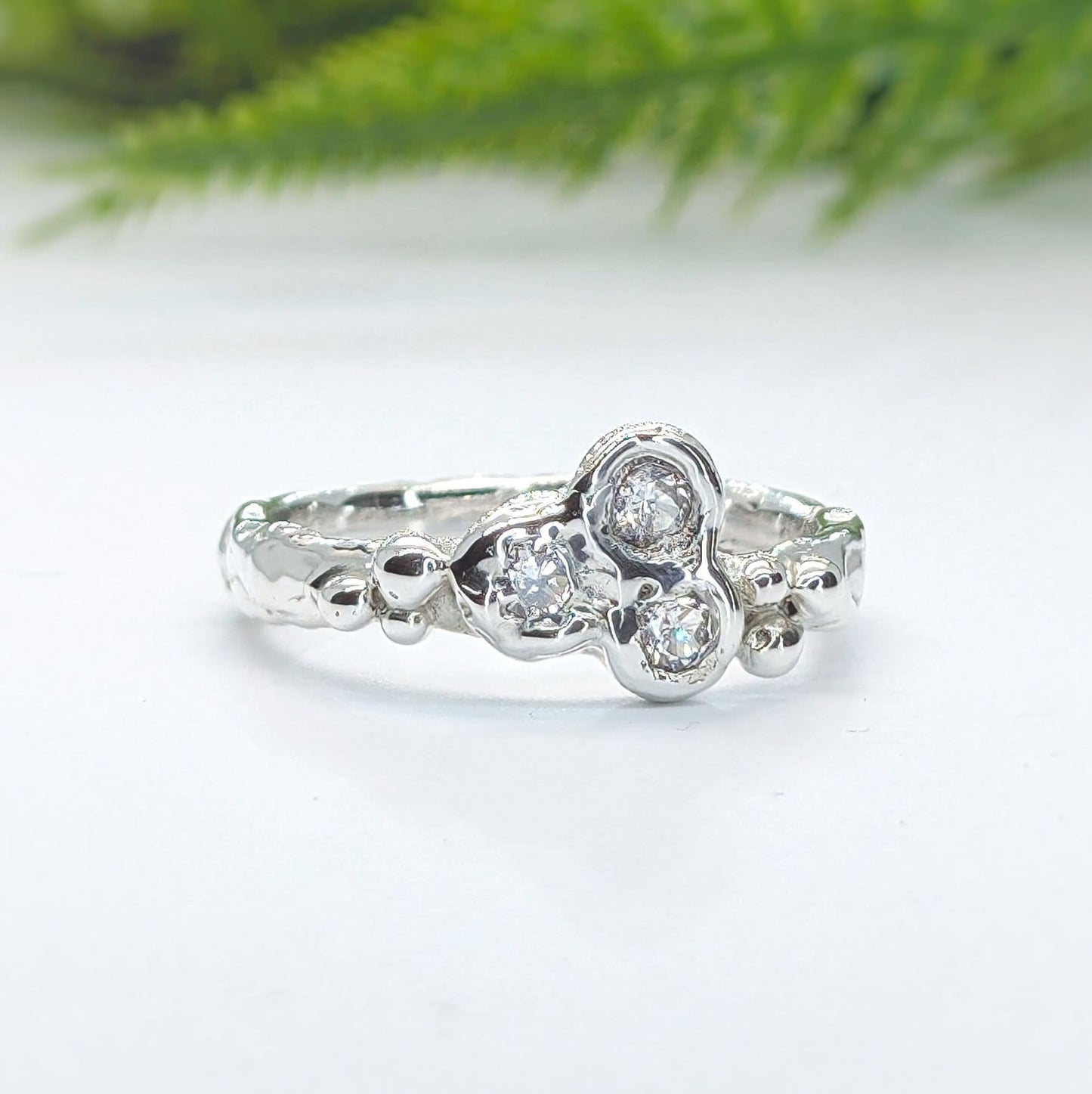 Handcrafted sterling silver cluster ring with three sparkling cubic zirconia stones, showcasing nature-inspired design.