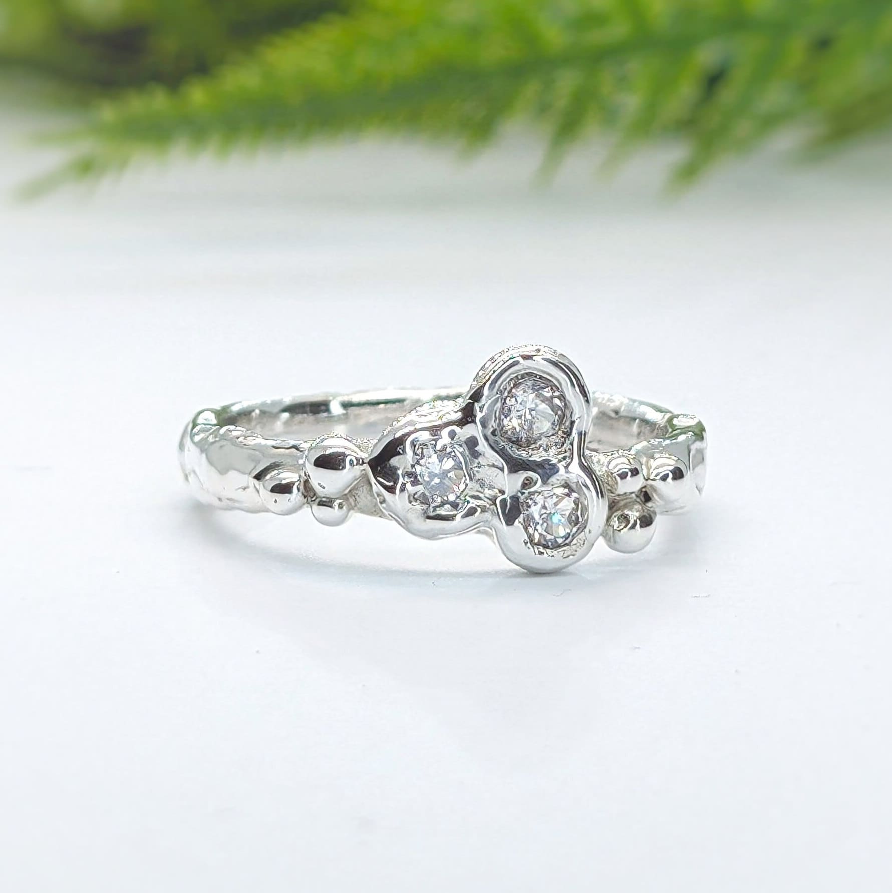 Handcrafted sterling silver cluster ring with three sparkling cubic zirconia stones, showcasing nature-inspired design.