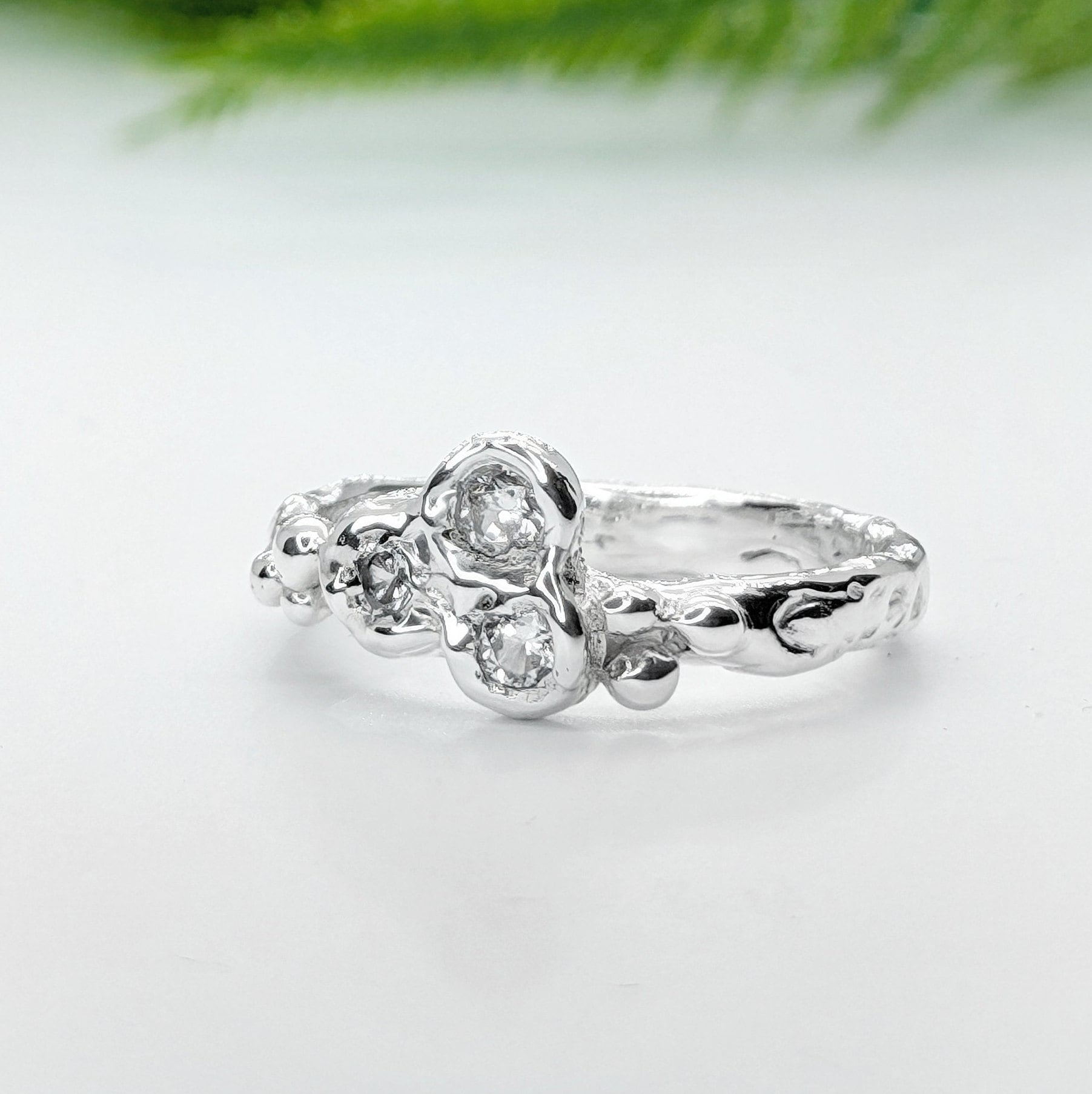 Handcrafted silver CZ cluster ring with organic band and three sparkling cubic zirconia stones.