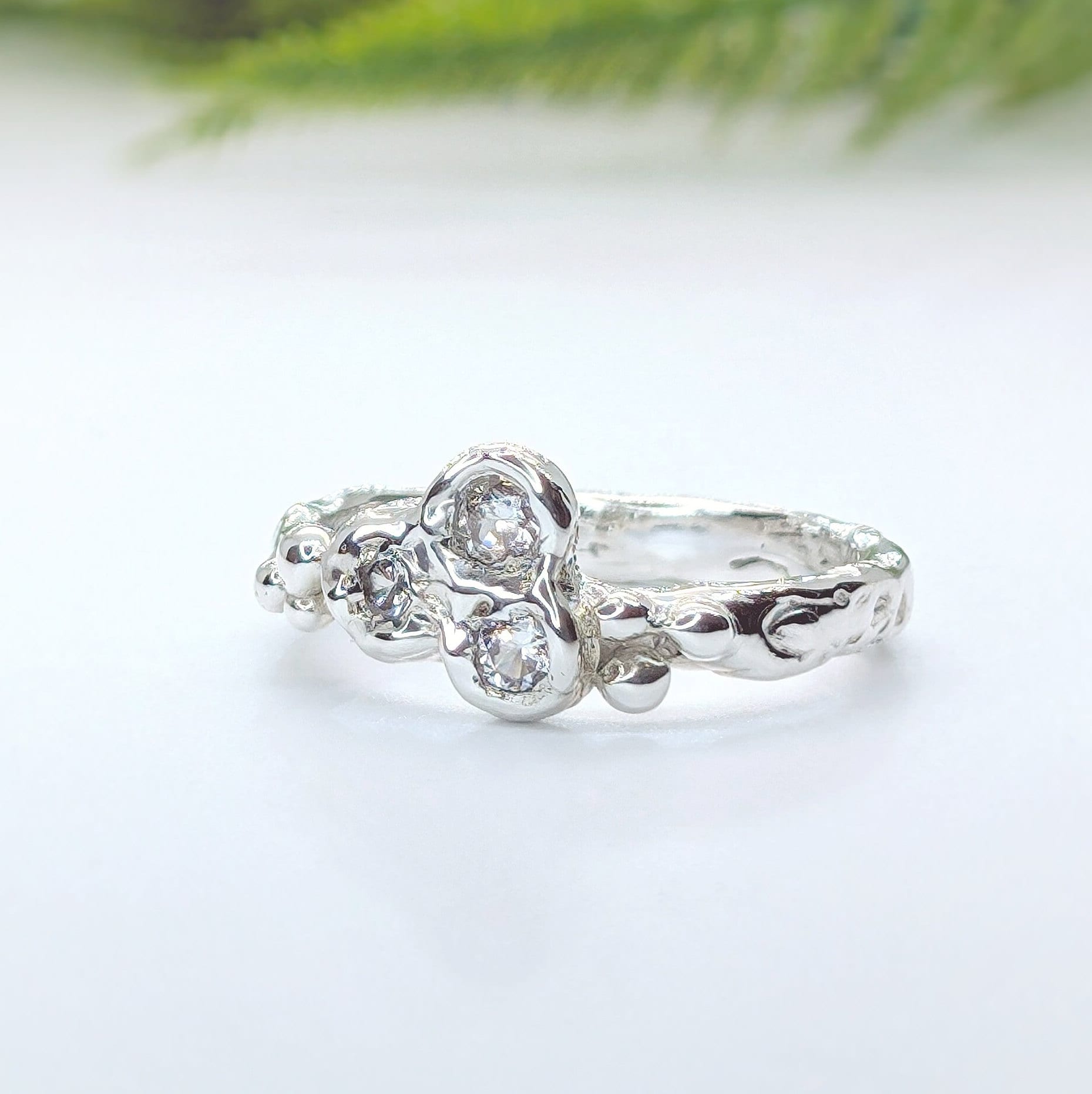 Sterling silver cubic zirconia cluster ring showcasing an organic molten band and sparkling stones.