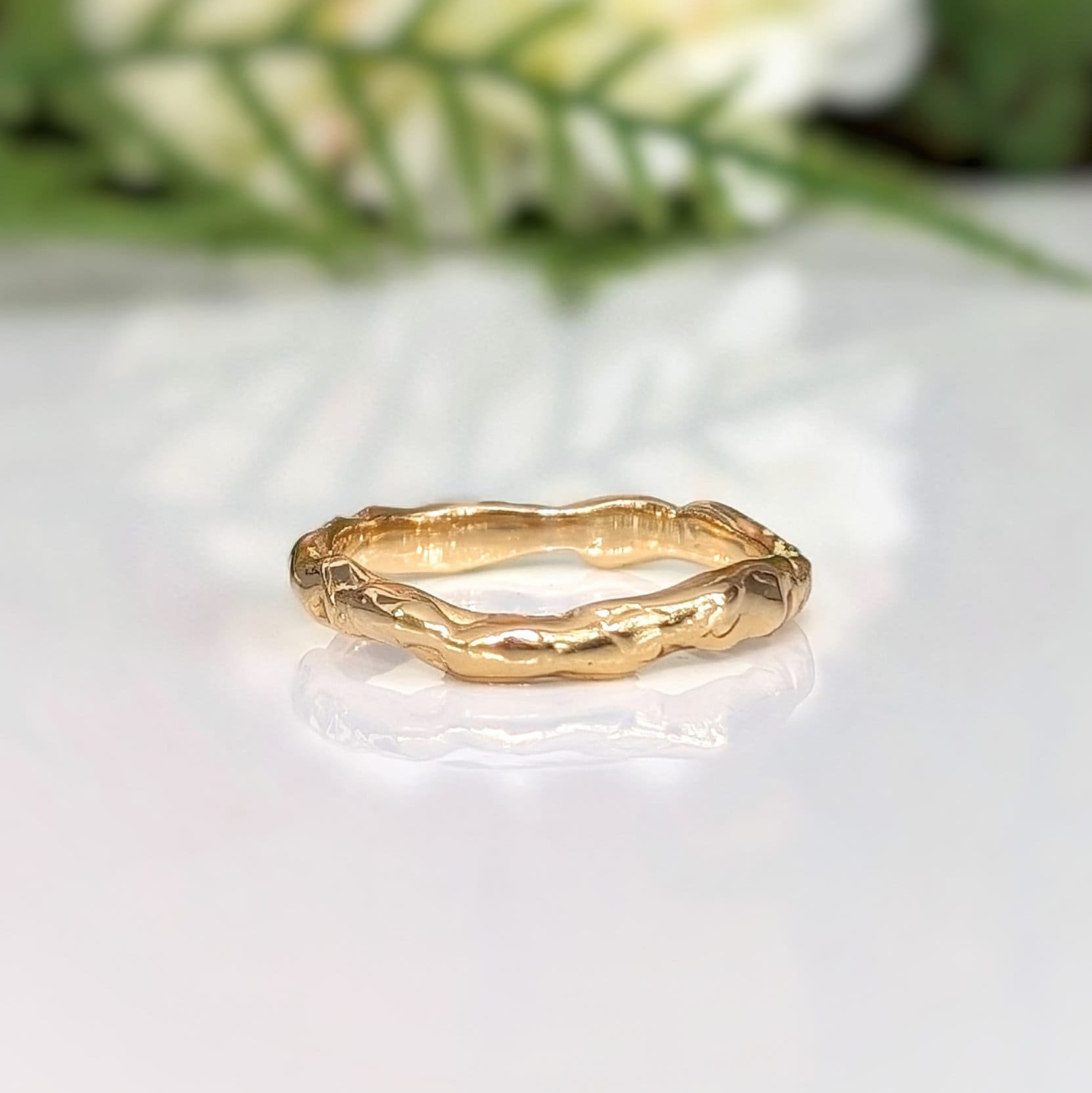 Handcrafted molten gold stacking ring showcasing a unique organic design, perfect as a wedding band or statement piece.
