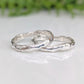Two handcrafted Molten Silver wedding bands showcasing unique abstract designs and a nature-inspired texture.